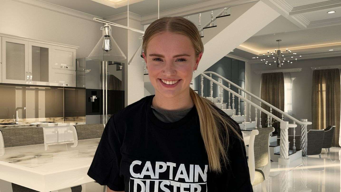 Captain Duster team member smiling in a clean living room after a professional home cleaning