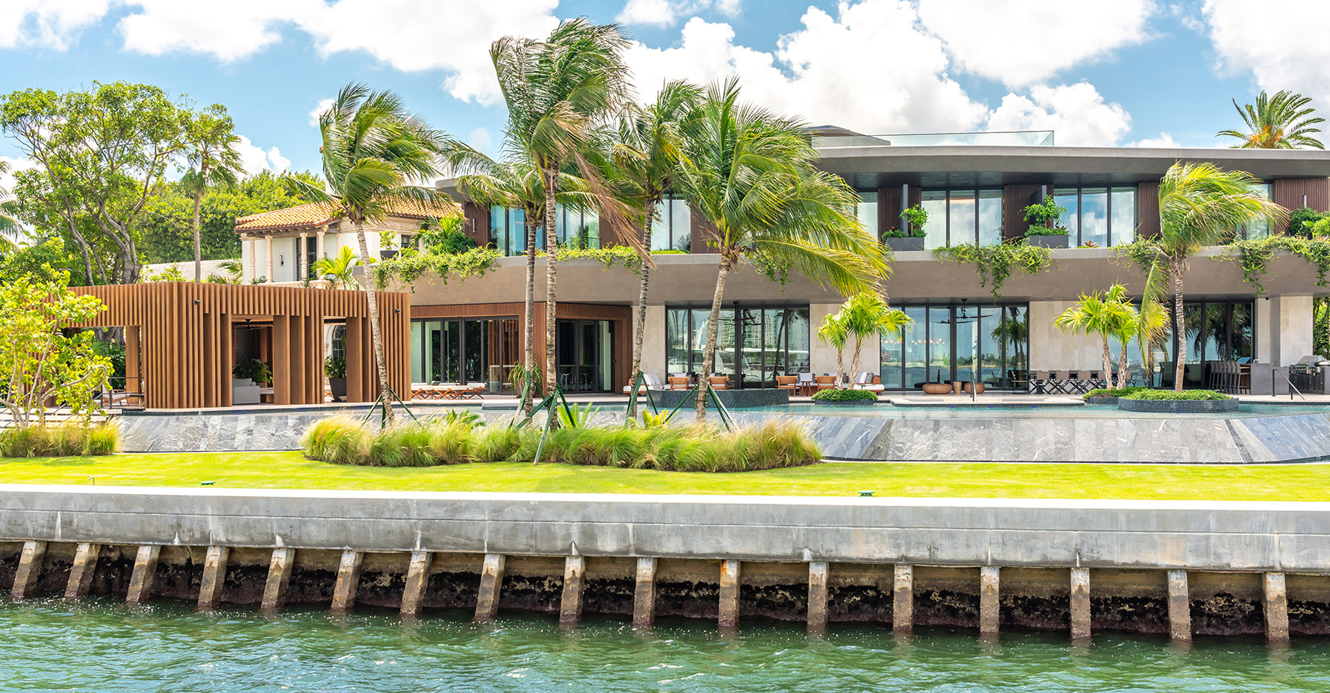 Beautiful beachfront home with crystal-clear exterior windows professionally cleaned by Captain Duster, reflecting sunlight and ocean views